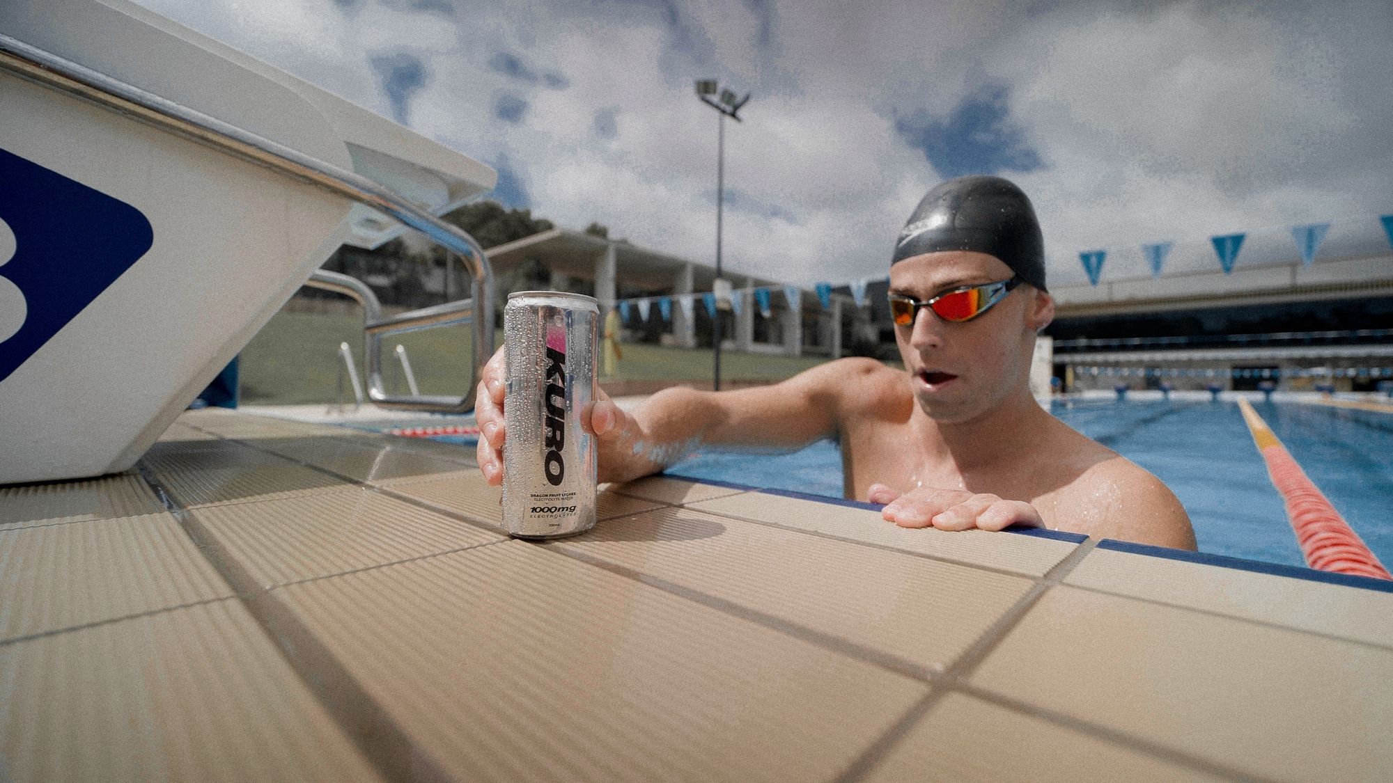 Swimmer at the pool edge with a KURO can
